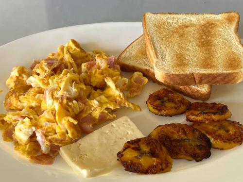 a plate of scrambled eggs with toast and butter at Legacy Boutique Hotel in Quesada