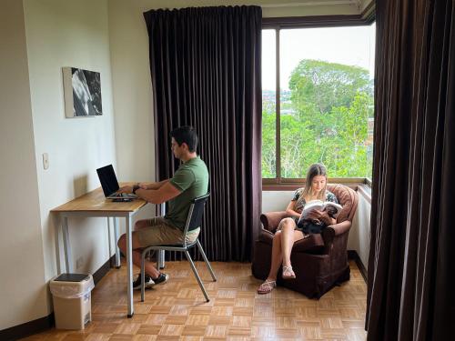 Quesada的住宿－傳統精品酒店，坐在一张桌子上的男人和女人,手提电脑
