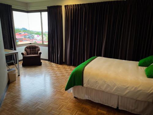 a hotel room with a bed and a chair and a window at Legacy Boutique Hotel in Quesada