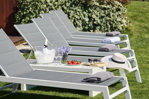 a white lounge chair and table on the grass at Villa Frida in Zambratija