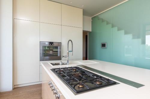 a kitchen with white cabinets and a stove top oven at Villa Frida in Zambratija