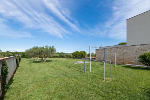 a grassy yard with a basketball hoop in front of a building at Villa Frida in Zambratija