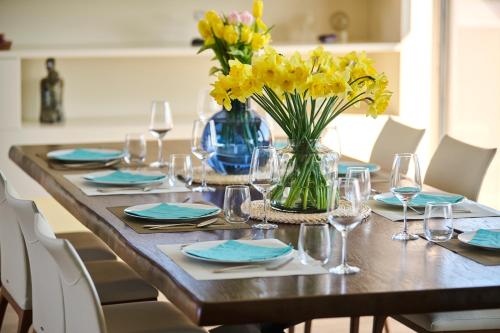 a dining room table with yellow flowers in a vase at Villa Frida in Zambratija