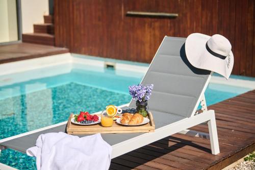 a tray of food on a chair next to a pool at Villa Frida in Zambratija