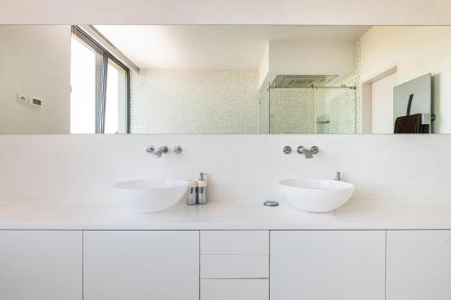 a white bathroom with two sinks and a mirror at Villa Frida in Zambratija