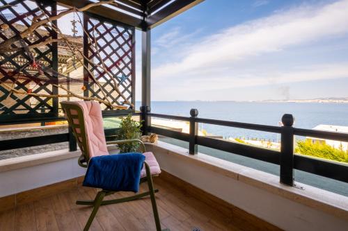 a balcony with a chair and a view of the ocean at Sunset House in Vlorë