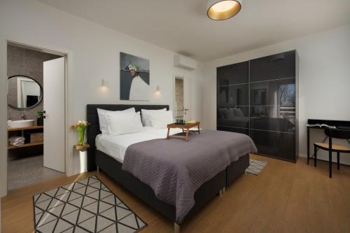 a bedroom with a large bed and a table at Villa Lu in Prkačini