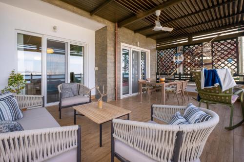 a porch with chairs and a table and a couch at Sunset House in Vlorë