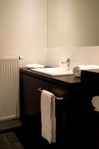 a bathroom with a sink and a towel on a counter at Vayamundo Oostende in Ostend