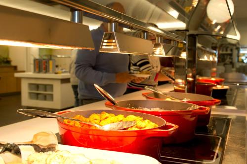 a person in a kitchen preparing food in pots at Vayamundo Oostende in Ostend