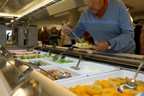 a man is preparing food in a buffet at Vayamundo Oostende in Ostend