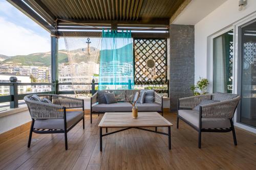 a living room with a couch and chairs and a table at Sunset House in Vlorë