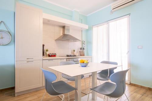 a kitchen with a white table and chairs at Sunset House in Vlorë