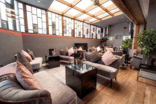 a living room filled with furniture and a large window at Karma Sanctum Soho Hotel in London