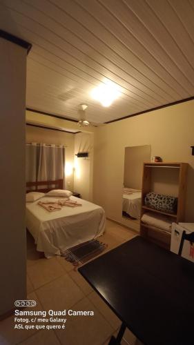 a room with two beds and a table in it at Pousada Girar do Sol in Nova Friburgo