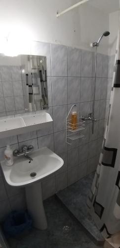 a white bathroom with a sink and a shower at Domum Universitate Dalles - Intercontinental in Bucharest