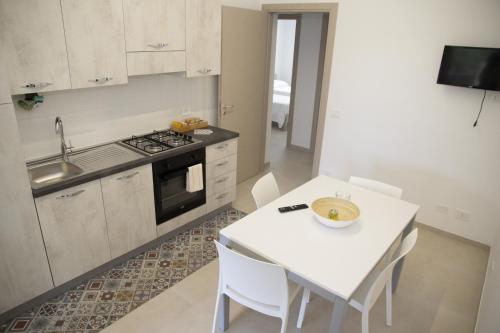 a kitchen with a white table and white chairs at Casa Raineri in Paceco