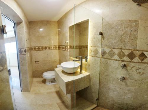a bathroom with a toilet and a sink and a shower at REAL DE LA PEÑA HOTEL 2 in Querétaro