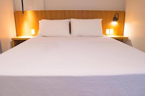 ein großes weißes Bett mit zwei Kissen darauf in der Unterkunft Salinas Premium Resort in Salinópolis