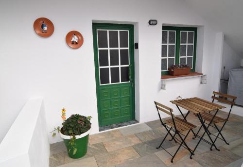 a green door on a white wall with a table and chairs at Vv. Apartamento Paco y Nina in Frontera