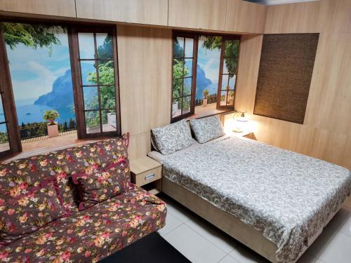 エイスクにあるGuest House Morskaya 265のベッドルーム1室(ベッド1台、ソファ、窓付)