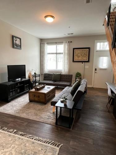a living room with a couch and a table at Uptown Townhouse Studio Apartment -WiFi-10 min walk to Spectrum Center in Charlotte