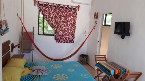 a room with a bed and a curtain on a wall at EncantaLuna in Holbox Island