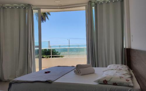 - une chambre avec un lit et une vue sur la plage dans l'établissement Areias do Mar | 2 Quartos, Terraço e Frente ao Mar A102, à Barra de São Miguel