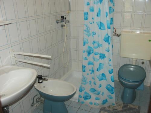 W łazience znajduje się niebieska toaleta i umywalka. w obiekcie Apartments Sara Maris w mieście Prižba