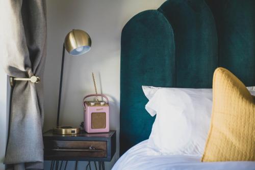 a bedroom with a bed and a pink clock on a night stand at The Burrow Escape in Branston