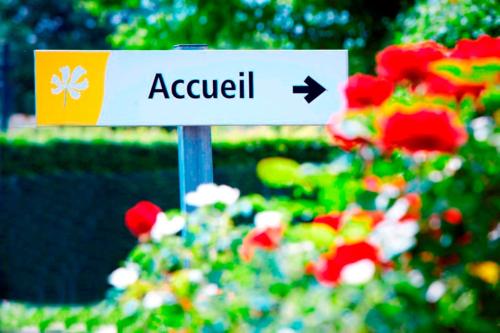 a sign for a garden with a flower garden at Premiere Classe Honfleur in Honfleur