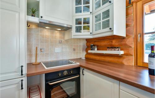 a kitchen with white cabinets and a sink and a stove at Lovely Home In Vinogradi Ludbreski in Ludbreg