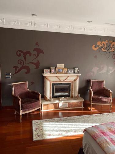 a living room with two chairs and a fireplace at Silivri Gazitepe'de 3 katlı, havuzlu lüks villa in Silivri