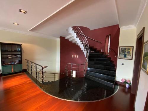 a spiral staircase in a house with a red wall at Silivri Gazitepe'de 3 katlı, havuzlu lüks villa in Silivri