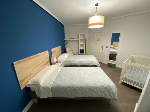 ein Schlafzimmer mit 2 Betten und einer blauen Wand in der Unterkunft Apartamento Argenta in Castro-Urdiales