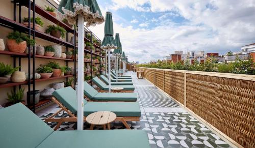a row of chaise lounge chairs on a balcony at Radisson Blu 1882 Hotel, Barcelona Sagrada Familia in Barcelona
