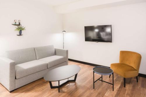 a living room with a couch and a chair at Radisson Blu 1882 Hotel, Barcelona Sagrada Familia in Barcelona