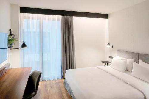 a hotel room with a large bed and a desk at Radisson Blu 1882 Hotel, Barcelona Sagrada Familia in Barcelona