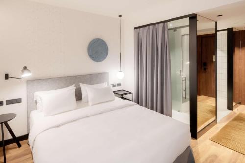 a bedroom with a large white bed and a desk at Radisson Blu 1882 Hotel, Barcelona Sagrada Familia in Barcelona