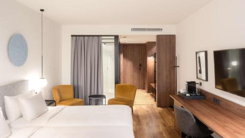 a hotel room with a white bed and a television at Radisson Blu 1882 Hotel, Barcelona Sagrada Familia in Barcelona