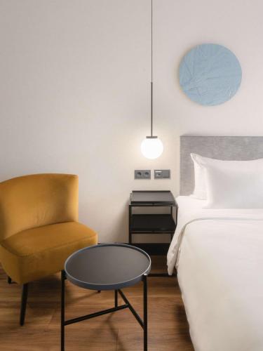a bedroom with a bed and a chair and a table at Radisson Blu 1882 Hotel, Barcelona Sagrada Familia in Barcelona