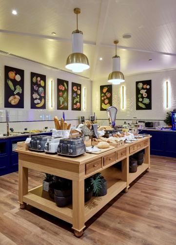 a large kitchen with a table filled with food at Radisson Blu 1882 Hotel, Barcelona Sagrada Familia in Barcelona