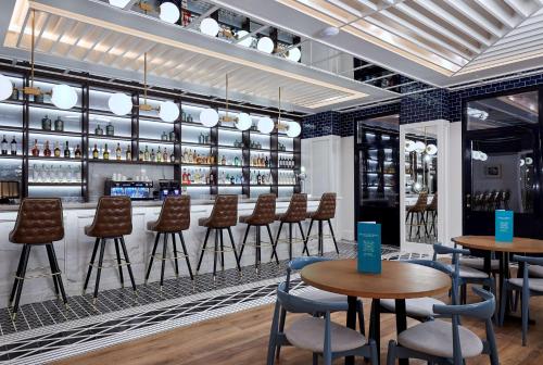 a restaurant with tables and chairs and a bar at Radisson Blu 1882 Hotel, Barcelona Sagrada Familia in Barcelona