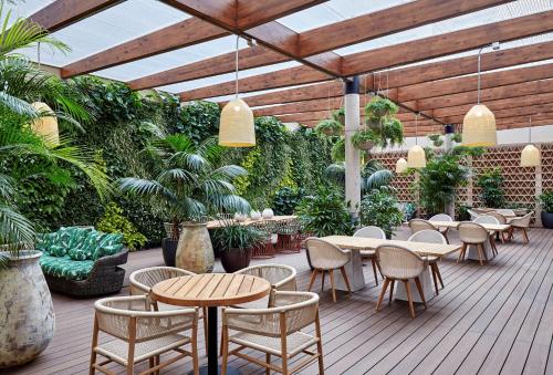 a patio with tables and chairs and plants at Radisson Blu 1882 Hotel, Barcelona Sagrada Familia in Barcelona