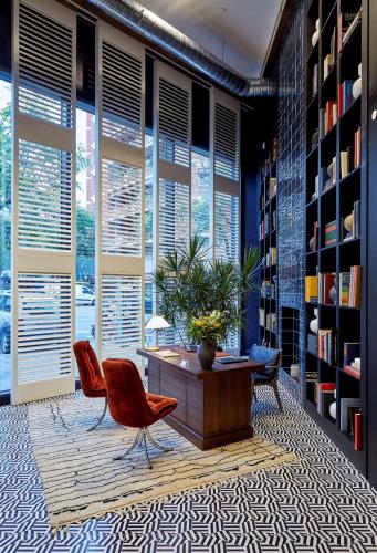 a library with two chairs and a table in a room at Radisson Blu 1882 Hotel, Barcelona Sagrada Familia in Barcelona