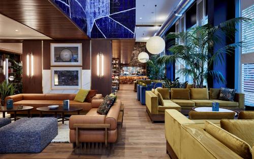 a lobby of a hotel with couches and tables at Radisson Blu 1882 Hotel, Barcelona Sagrada Familia in Barcelona