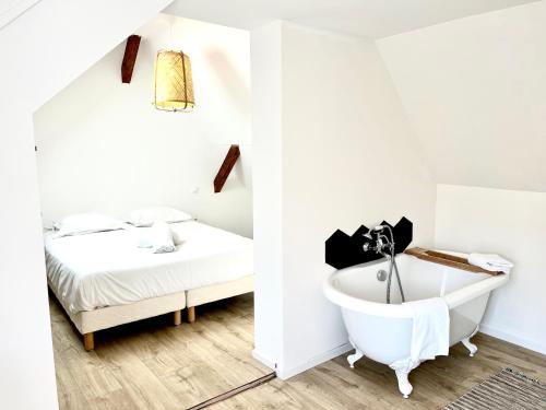 a bathroom with a bath tub next to a bed at Sous les toits avec garage et terrasse à Ribeauville in Ribeauvillé