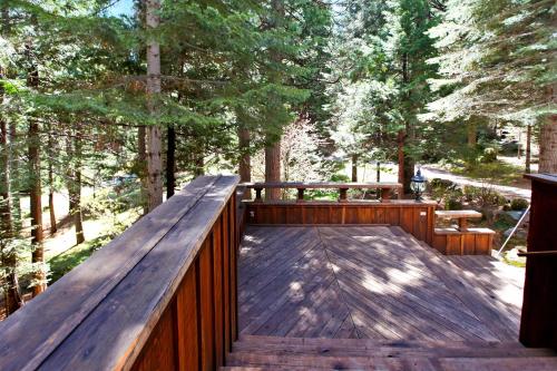a wooden deck with a wooden fence and trees at Little Ahwahnee Inn Entrance to Yosemite in Fish Camp