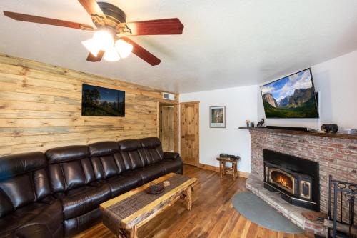 a living room with a leather couch and a fireplace at Magic Escape in Oakhurst