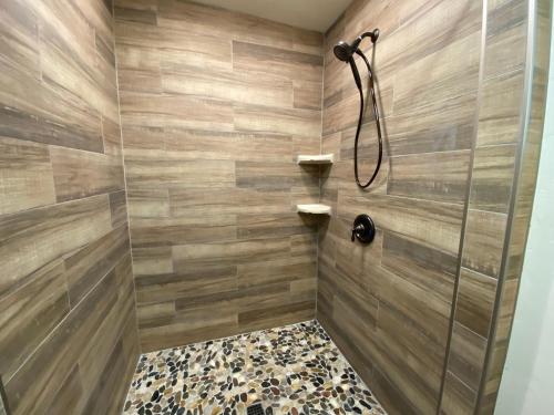 a bathroom with a shower with wooden walls at Magic Escape in Oakhurst